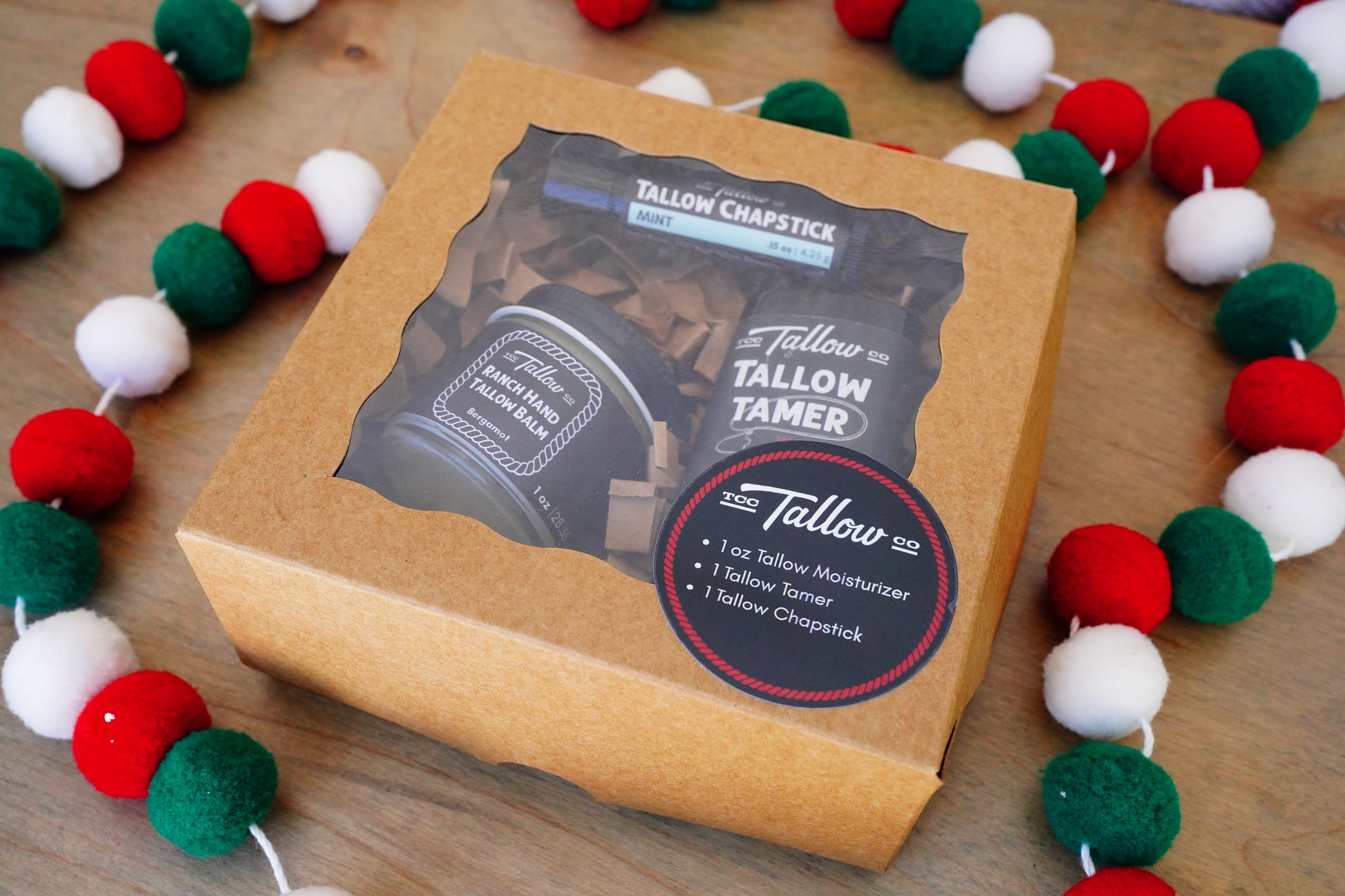 Tallow Chapstick packaging on a wooden surface with decorative garland