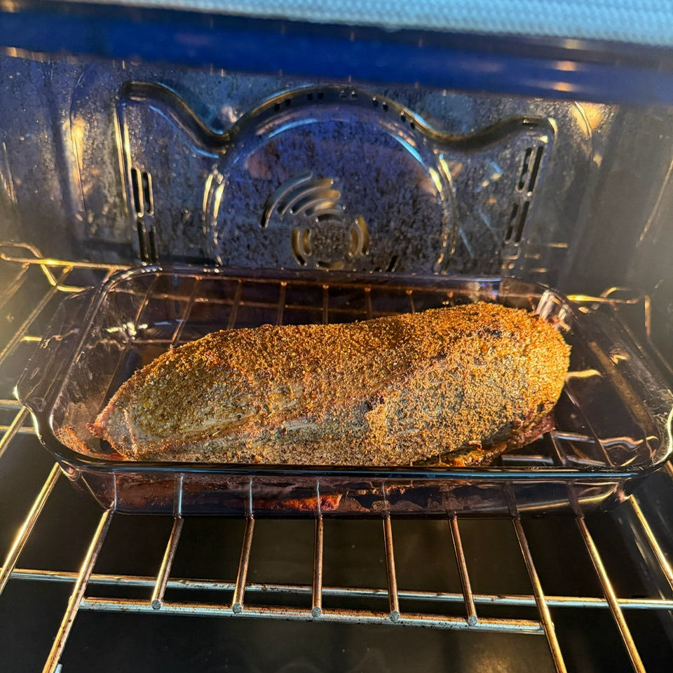 Beef roast in a glass dish in oven.