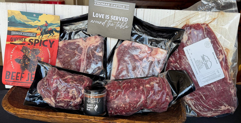 Assorted packaged meats on a wooden tray with a sign and a box of beef jerky.