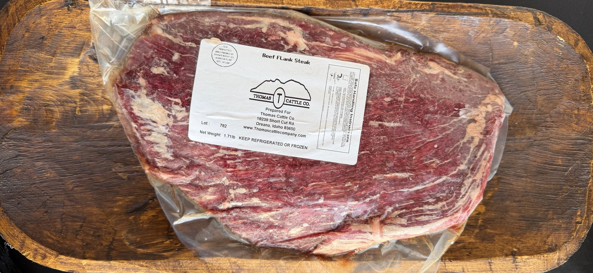Raw flank steak with a label on a wooden cutting board