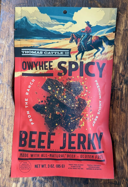 Owyhee Spicy Beef Jerky package on a wooden tray with a dark background