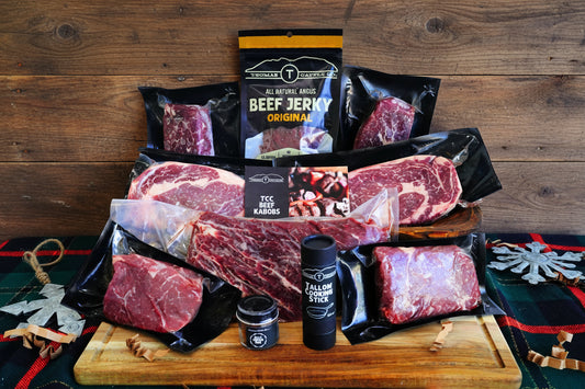 Assortment of raw meat and packaged beef jerky on a wooden cutting board with a white background.
